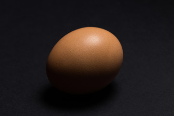 Egg on a black background, close-up, side view