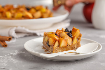 Piece of vegan apple pie with cinnamon, raisins and caramel, gray background.