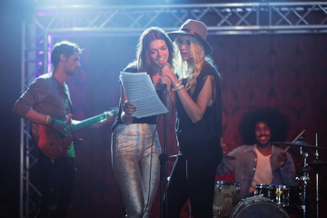 Female singers with male musicians practicing at nightclub