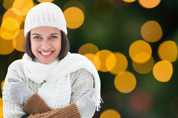 Brunette in warm clothing against blurry yellow christmas light circles