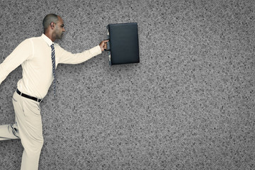 Businessman running with briefcase against grey background
