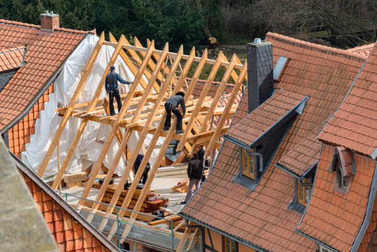 Zimmerleute und Dachdecker bei der renovierung eines Dachstuhls