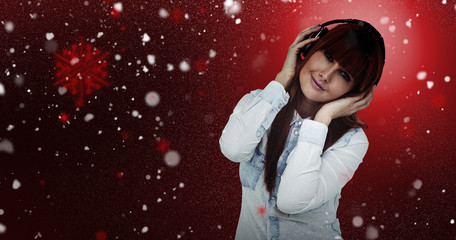 Portrait of a hipster woman with headphones against snow