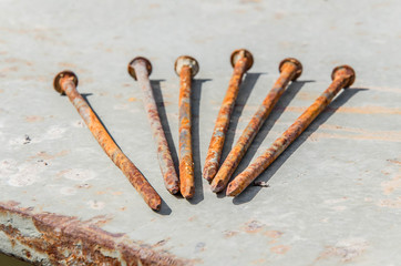 Rusty nails against the background of old metal