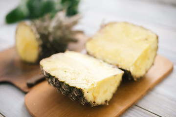 Sliced fresh pineapple on a wooden background in sunlight