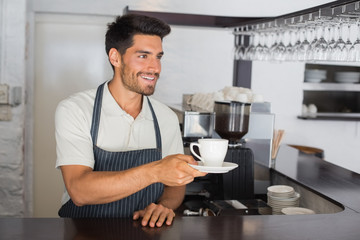 Barista holding cup of coffee at the cafÃƒÂ©