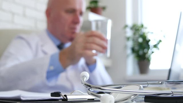 Blurred Image with a Doctor Drinking a Glass with Water
