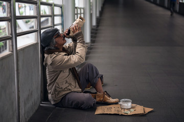 Sad Homeless old man drink beer
