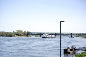 Containerschifffahrt auf dem Rhein / Ein Containerschiff unterfährt die Südbrücke in Mainz auf dem Fluss Rhein.