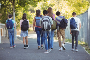 Rear view of school kids walking on road in campus © WavebreakmediaMicro