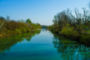 Fototapeta na wymiar Blue river flowing across green forest