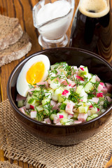 Traditional summer Russian cold soup with kvass, okroshka with ham and vegetables