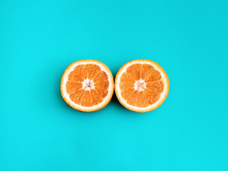 Citrus fruit Flat lay Two halves of orange are lying on bright blue background Photo template in top view with copy space