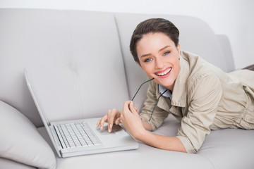 Beautiful young woman using laptop on sofa at home