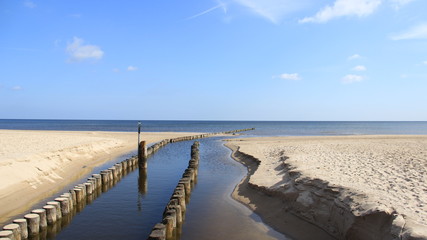 Baltic Sea During Springtime With Wooden Groynes And Fresh Water Flows Into The Sea. Germany