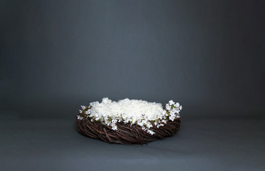 Digital Prop for photographing infant babies, a cozy fantasy nest with soft bedding and decorative white flowers on gray background