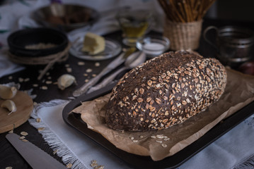 Oat bread with butter, garlic, salt, oil on a brown table for breakfast