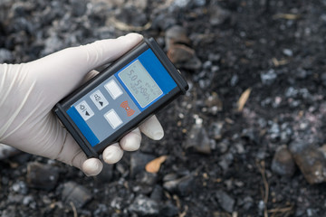 Radiation supervisor in glove with geiger counter checks the level of radiation