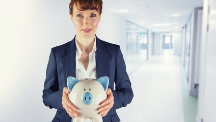 Businesswoman showing piggy bank against college hallway