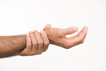 Closeup unhappy man suffering from wrist, arm pain and injury on white background. Health care and medical concept.