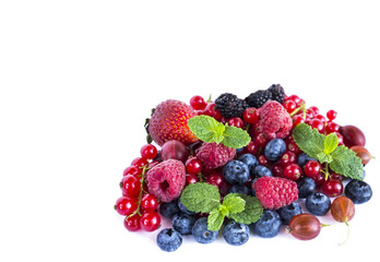 Ripe red currants, raspberries, blueberries,  strawberries, gooseberrie, blackberries with a mint leaf. Sweet and juicy fruits with copy space for text. Background of mix fruits on a white. Top view.