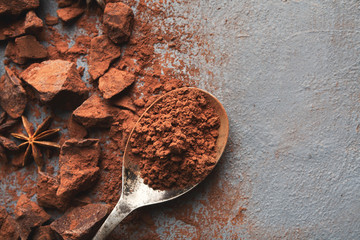 Crushed chocolate pieces and cocoa on gray background