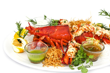 Red lobster with vegetables on a white plate. Isolated