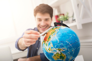 Man dreaming about travel, looking at globe