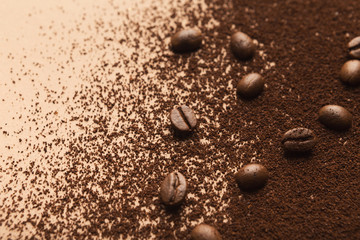 Fototapeta na wymiar Heap of brown coffee beans and ground roasted seeds