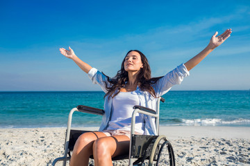 Disabled woman with arms outstretched at the beach - Powered by Adobe