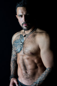 Fit model with tattoo art on skin. Bearded man with tattooed chest. Macho  with sexy bare torso. Sportsman or athlete with stylish beard and hair.  Sport or fitness and bodycare. Strength and