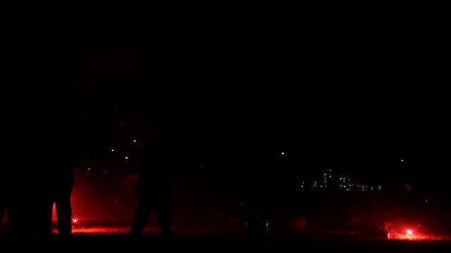 Workers lighting fireworks; explosions and smoke