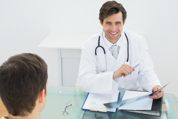 Smiling doctor explaining xray reports to patient