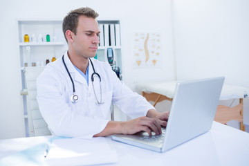 Fototapeta na wymiar Focused doctor working with laptop