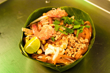 Pad Thai noodles with prawn, egg wrapped with banana leaves.