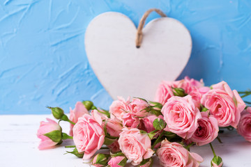 Plakat Tender pink roses flowers and white heart on light blue textured background.
