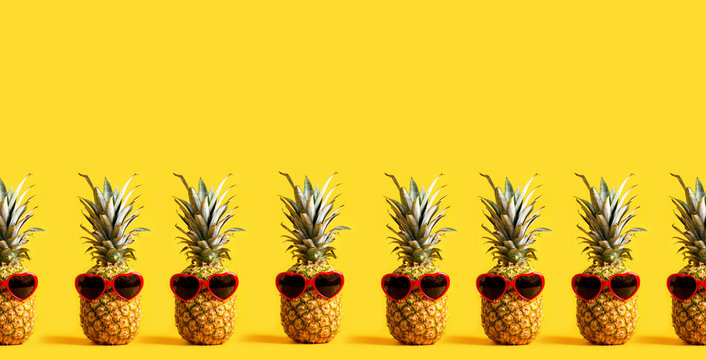 Series of pineapples wearing sunglasses on a yellow background