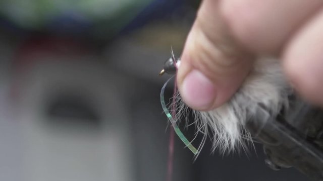 Tying a fly fishing fly outdoors, slow motion