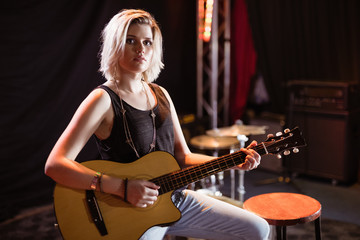 Fototapeta na wymiar Portrait of female musician playing guitar