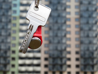 House keys on background of new buildings. Buying an apartment, real estate agent. Rental property
