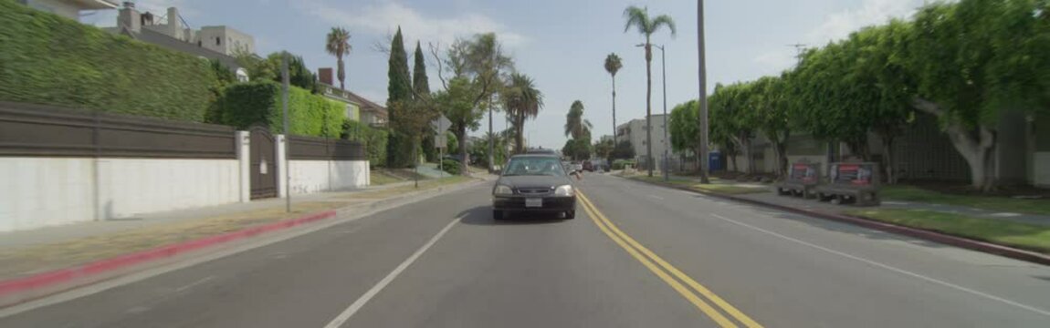 Rear View Of A Driving Plate: Car Travels Through Residential Area On Wilton Place In Los Angeles From 5th Street To 2nd Street.