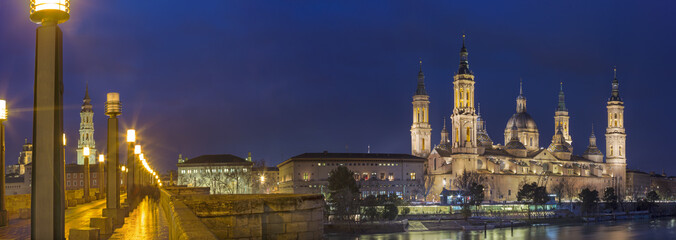 Fototapeta na wymiar Zaragoza - The panorama with the bridge Puente de Piedra and Basilica del Pilar at dusk.