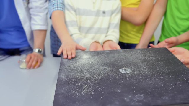 Children looks at Chladni plate with dancing sand