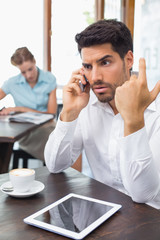 Fototapeta premium Serious man using mobile phone in coffee shop