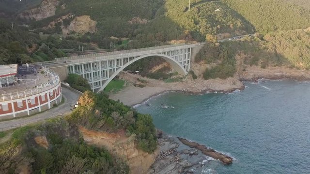 Ponte ad arco stradale in riva al mare. Vista aerea con drone.