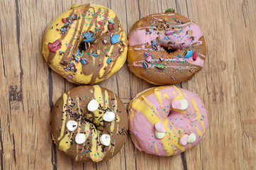 Obraz na płótnie Canvas Decorated doughnuts on a wooden background