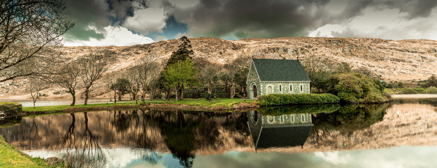View of the Gouganebarra Lake and the river Lee outside of Saint Finbarr's Oratory chapel. - obrazy, fototapety, plakaty