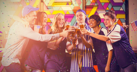 Group of friends toasting glass of beer in party against flying colours
