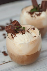 Iced Mocha Frappe Coffee with Whip Cream, Summer Drinking times. Coffee Beans. rustic textured Wooden Background. Mint Leaves