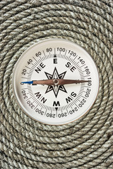 Fototapeta na wymiar compass on old twisted rope